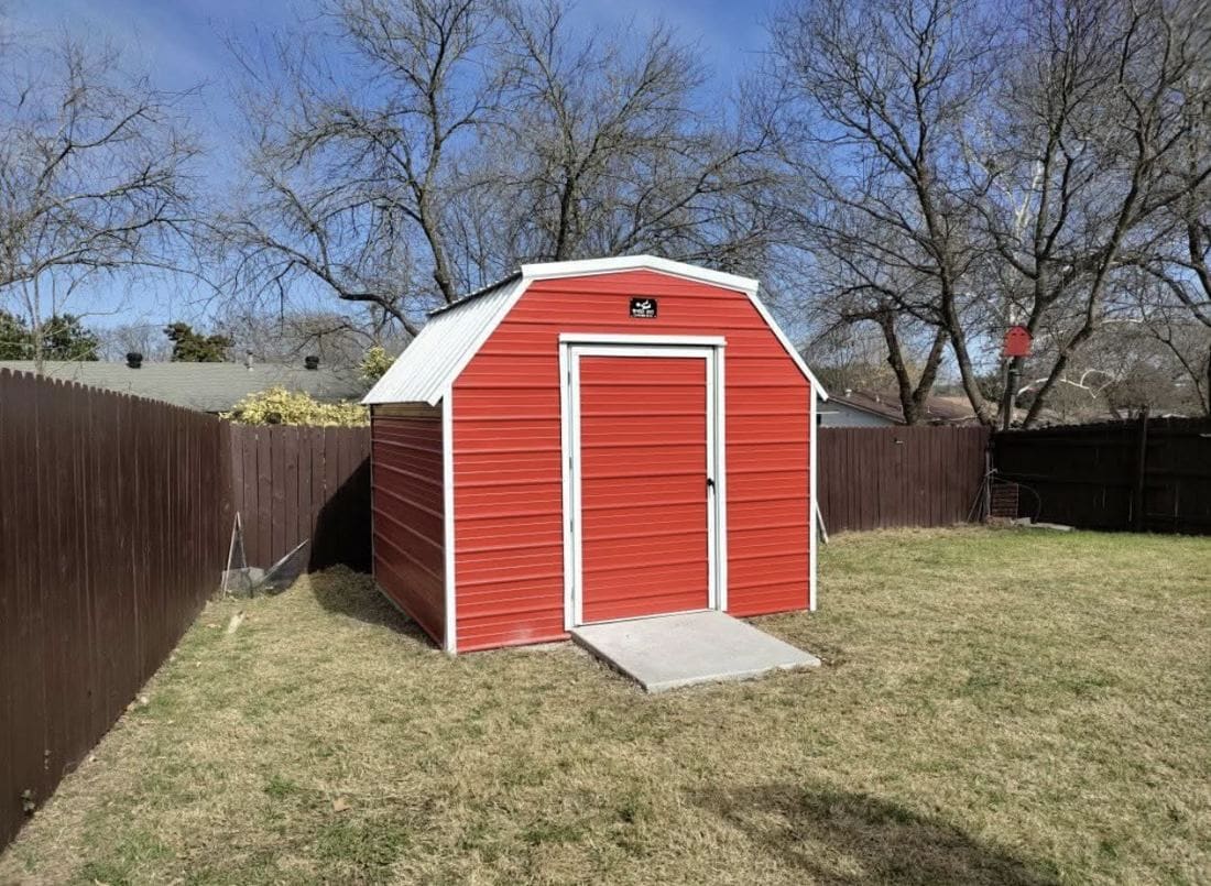 Finished custom storage shed with side-entry door and ventilation in a Texas backyard.